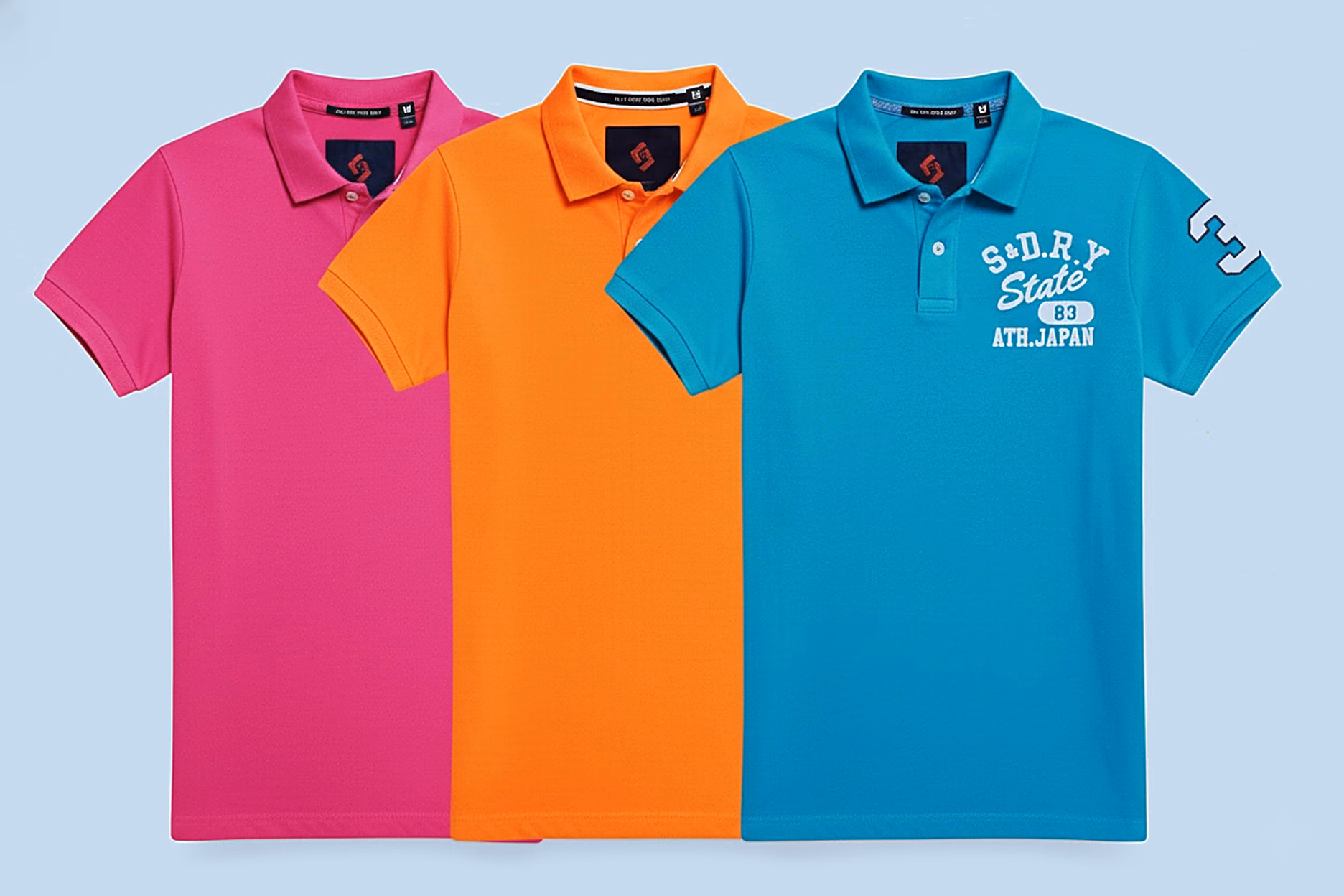 pink orange teal polo shirts flat lay